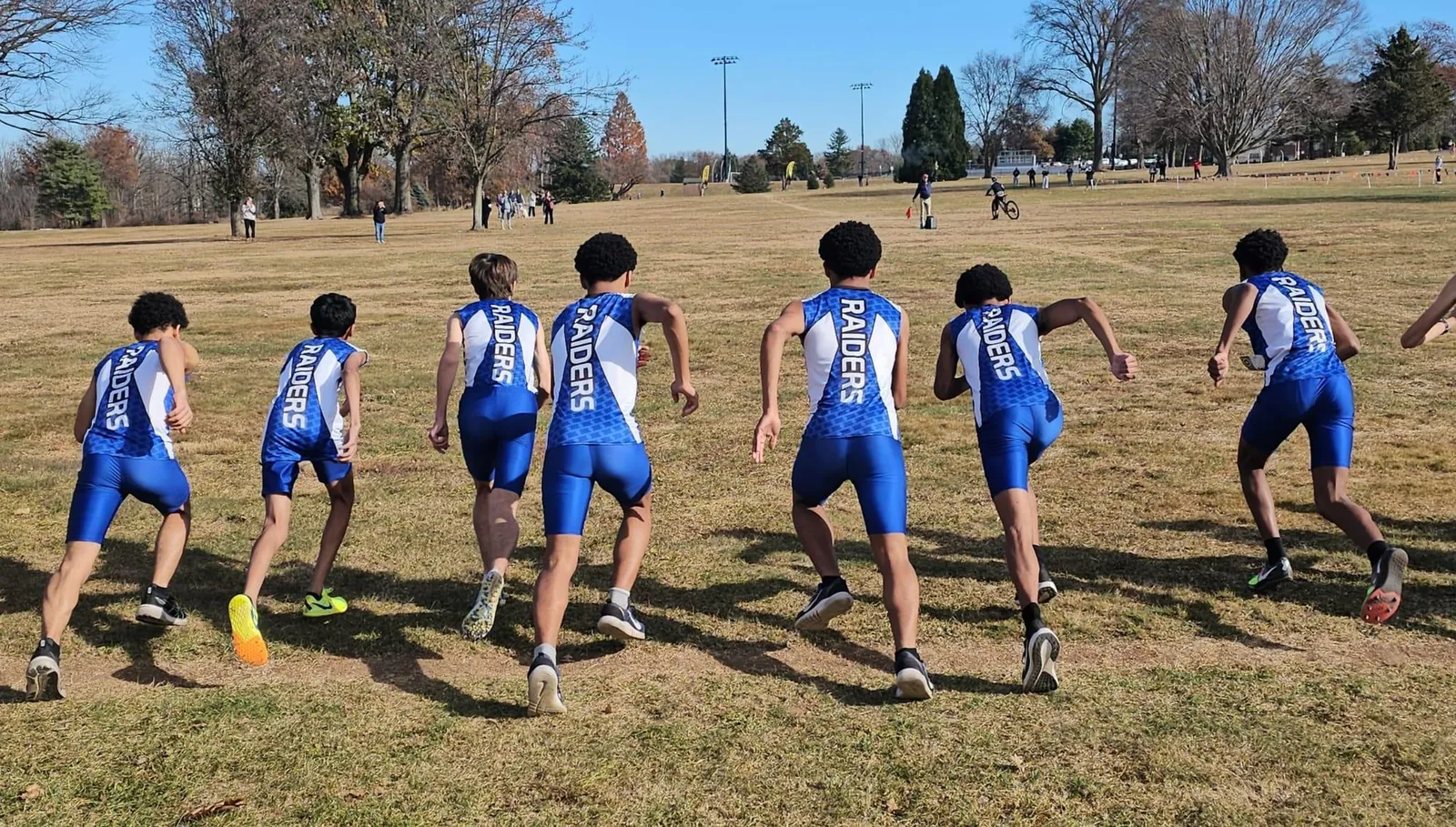 Line of Raiders runners in blue uniforms at the start of a race