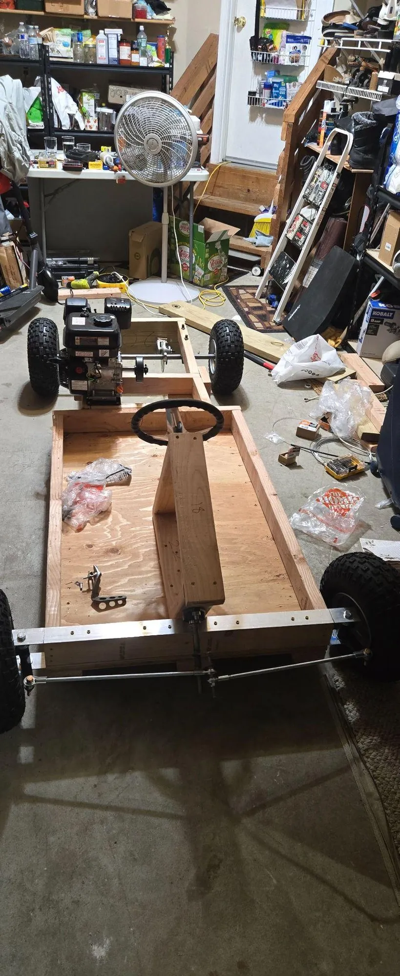 Car frame in a garage with steering wheel, column and front axle installed