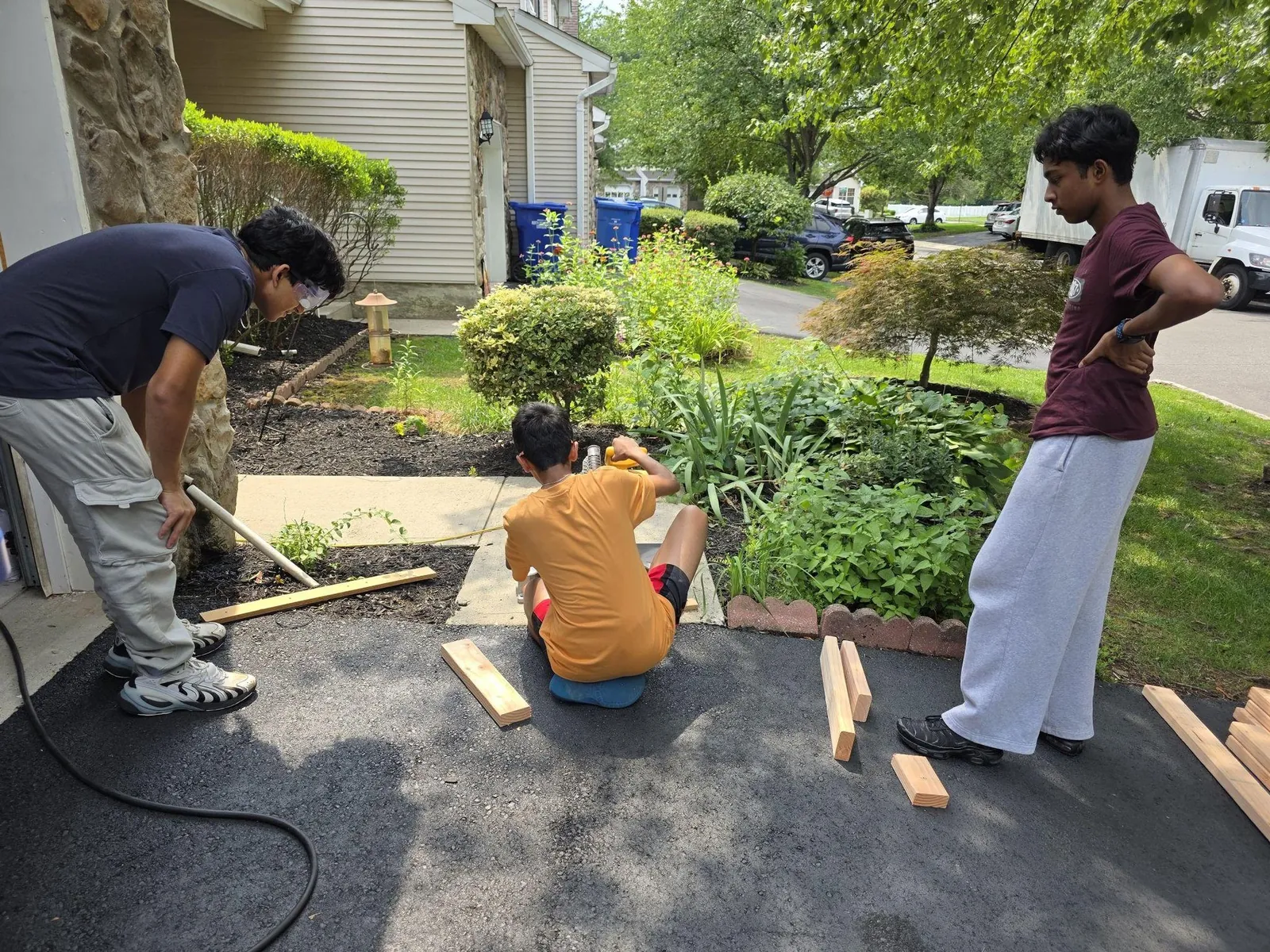 Team cutting wood in front of a house