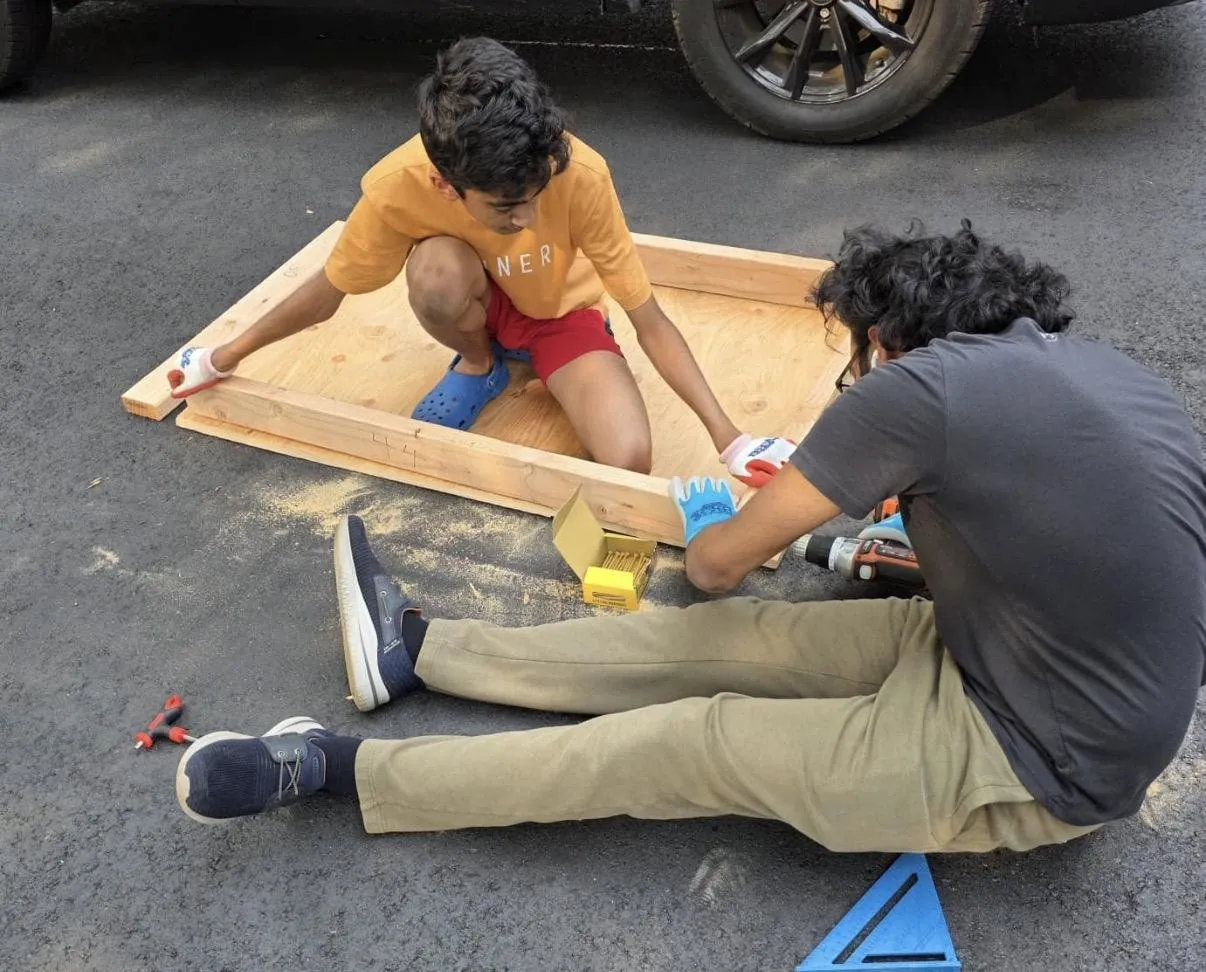 Two team members fastening the wooden floor frame
