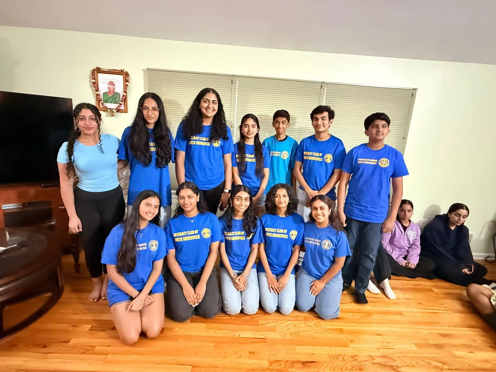Interact Club members posing together indoors in matching shirts