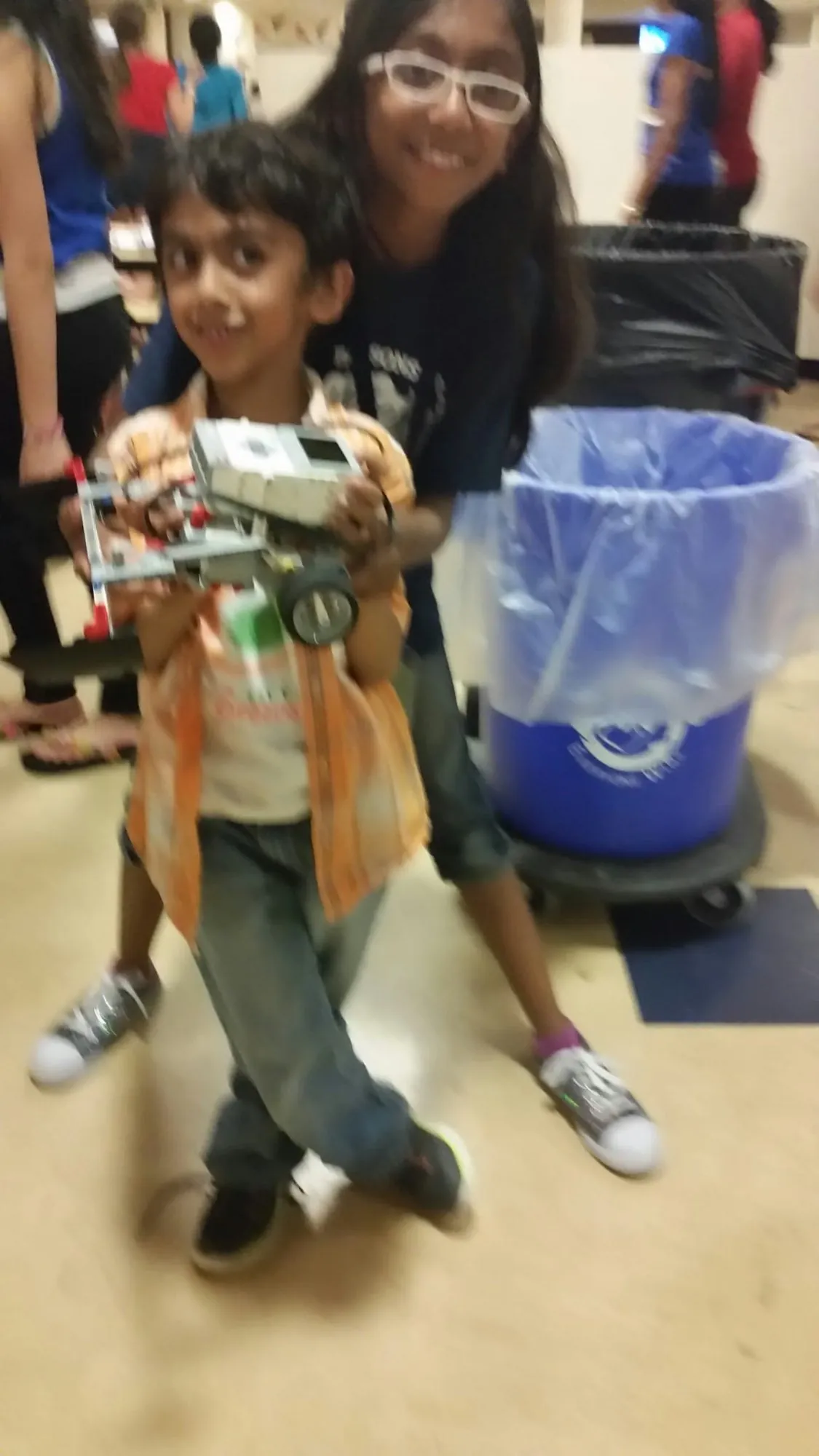 A young Anish holding a LEGO robot he built