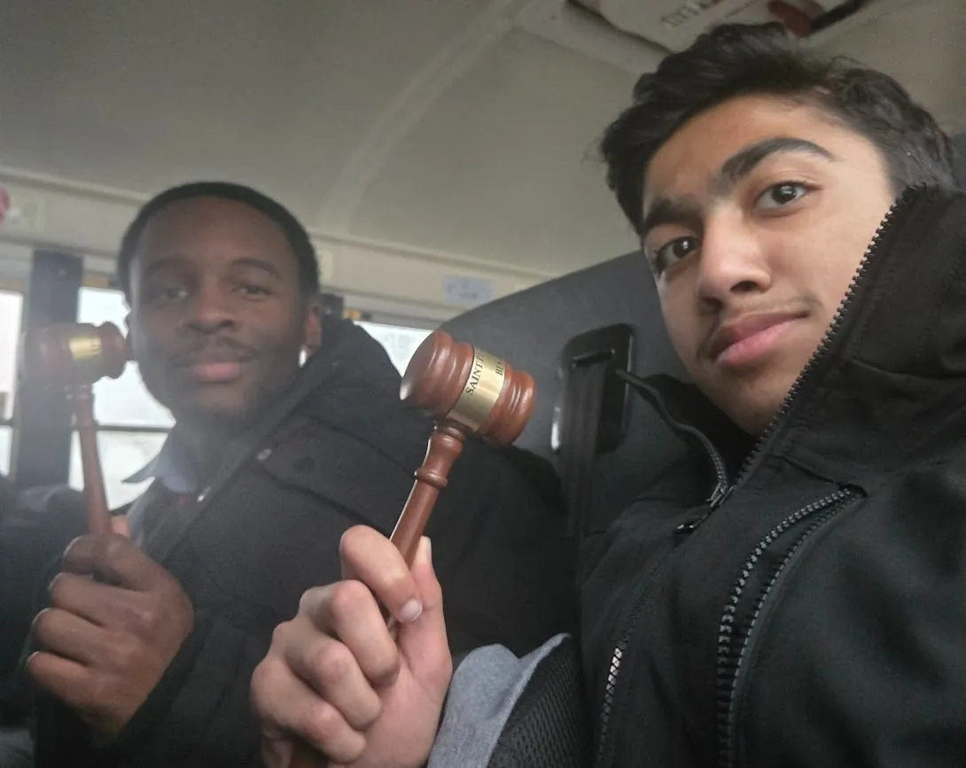 Anish and a fellow delegate holding gavels on a bus